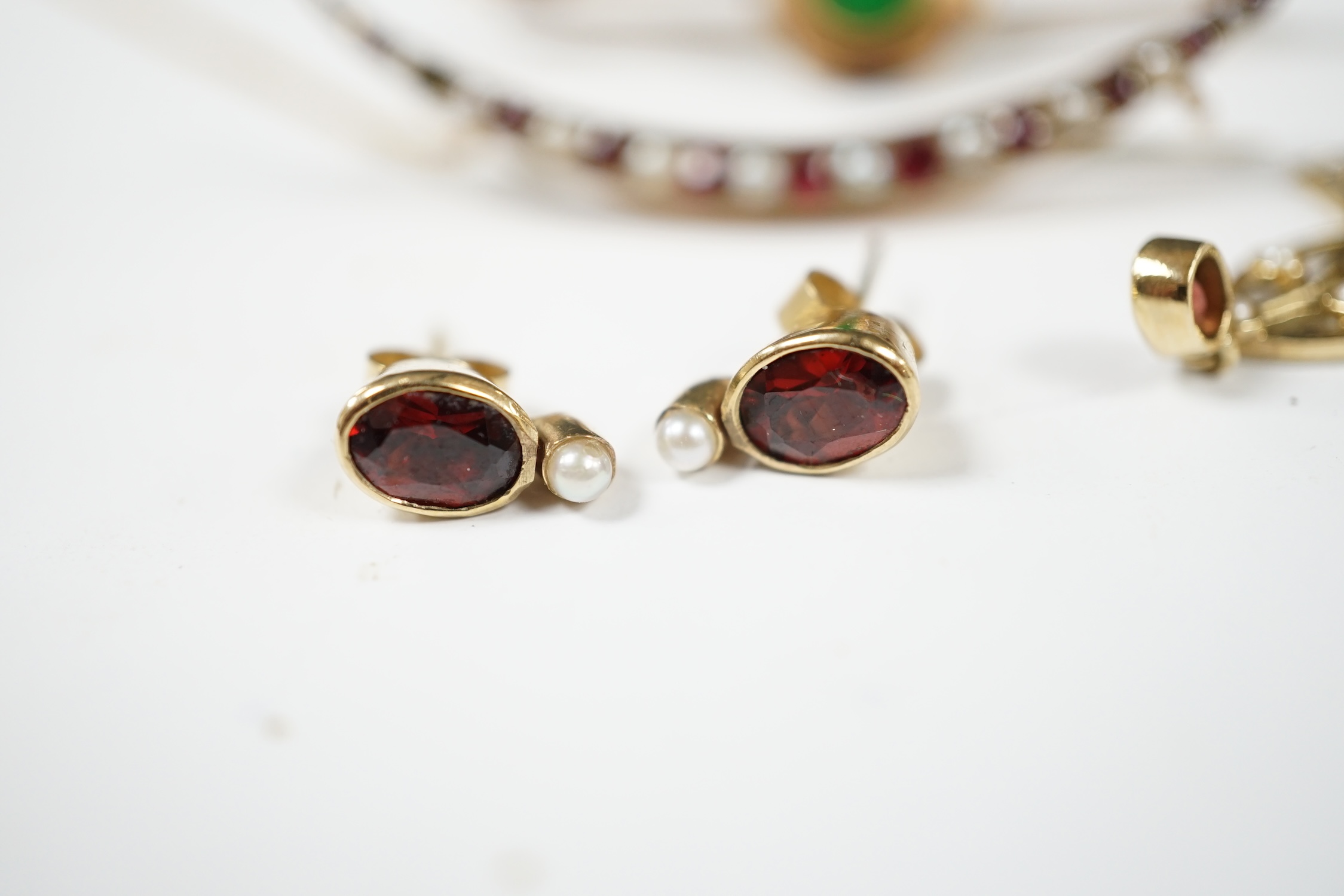 Sundry jewellery including a 9ct and gem set crescent brooch, 51mm, a 9ct, garnet and seed pearl set pendant, a 14ct and jade set bar brooch and a pair of gem set ear studs. Condition - fair to good